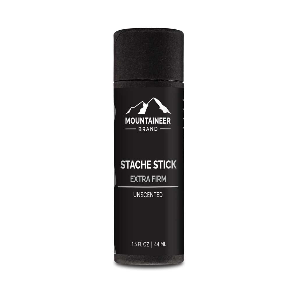 A black bottle of Extra Firm Hold Stache Stick by Mountaineer Brand Products, all natural and free of chemicals, on a white background.