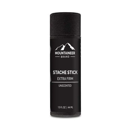 A black bottle of Extra Firm Hold Stache Stick by Mountaineer Brand Products, all natural and free of chemicals, on a white background.